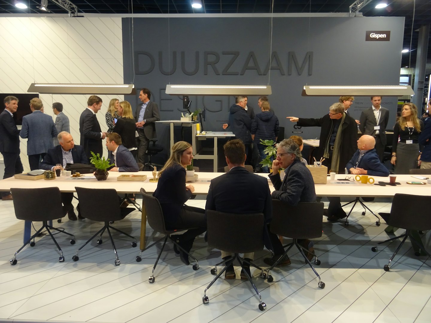 Professionals networking at a table in a modern event space.