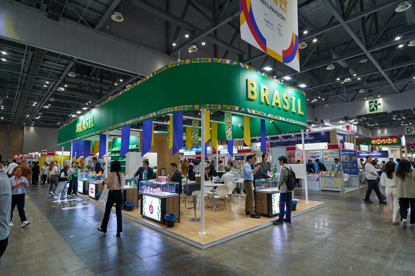 Attendees walk through a busy trade show hall filled with exhibition booths.