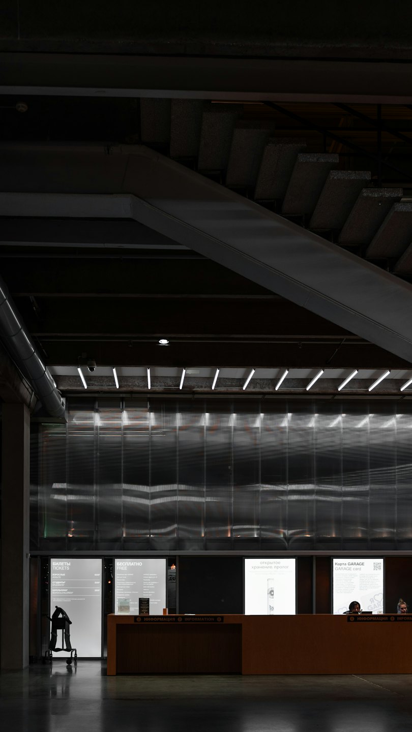 Staff working at a modern wooden reception desk with display panels.